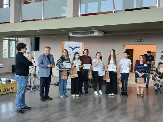Група младежи с грамоти в светло фоайе.
